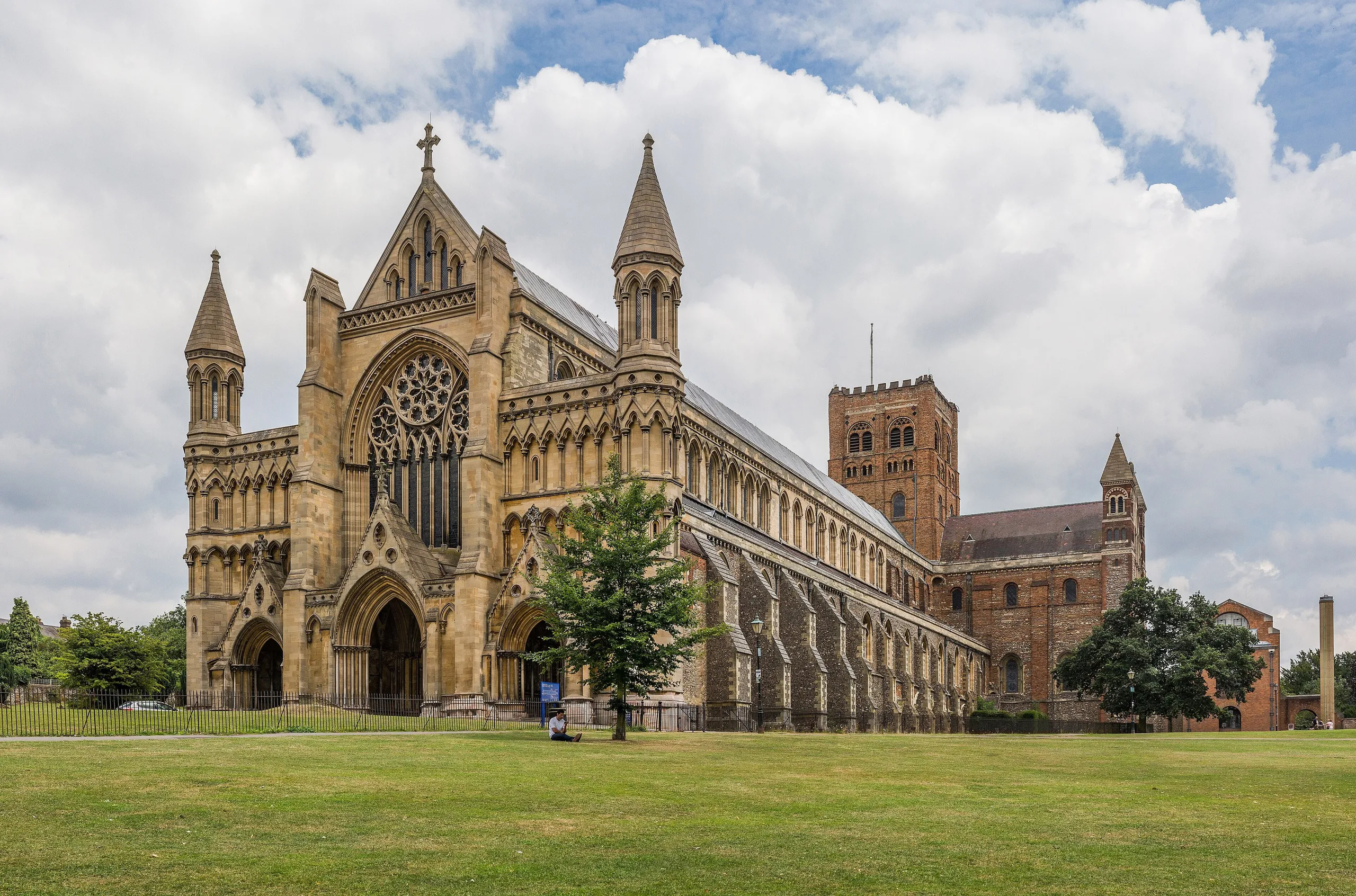 The west front of St Albans Cathedral seen across the lawn on a bright day